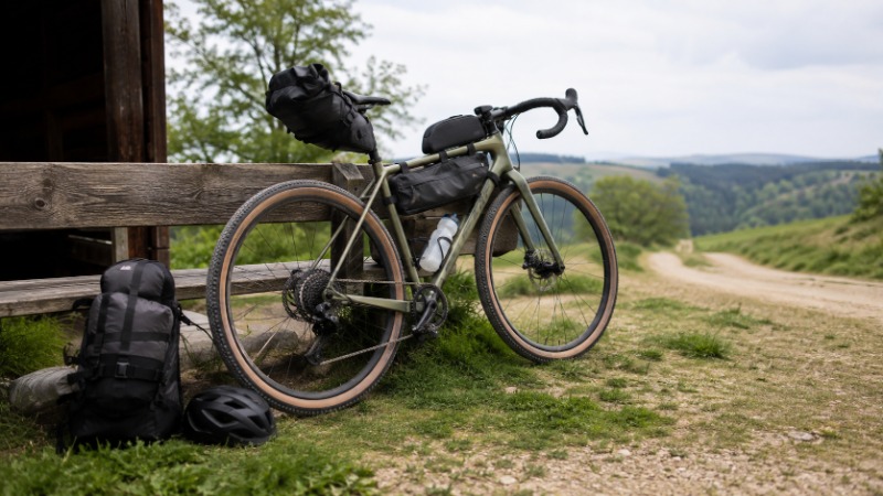 Gravel kolo s brašnami stojící na polní cestě mezi poli